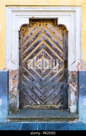 Porte baroque dans un vieux mur, cadre décoratif et une pierre porte. Vintage entrée à partir de planches de bois massif. Knocker et poignée de métal rouillé. Banque D'Images