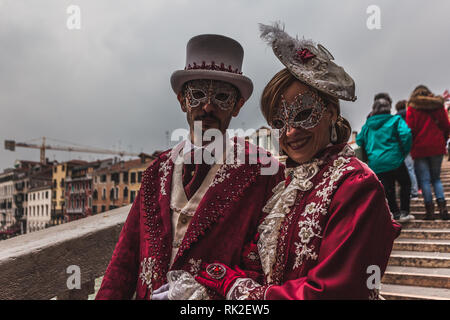 Venise, Italie - 09 février 2018 : paire de masques de carnaval habillé en rouge sur un pont Banque D'Images