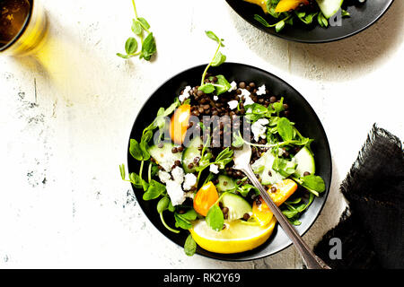 Lentilles noires salade de pousses de pois Vinaigrette photographié sur un fond blanc. Banque D'Images