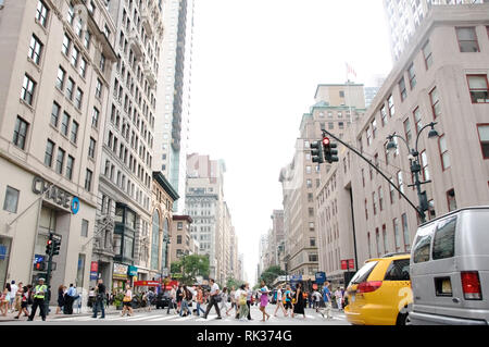 Les personnes qui traversent la voie piétonne sur l'une des rues de la 5e Avenue à New York. Banque D'Images
