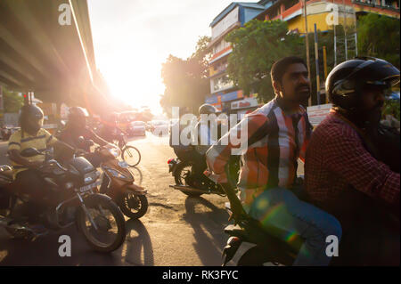 Soleil de l'après-midi Cours d'eau par les usagers sur leur moto sin Chennai, Inde du Sud, en tant que chef des travailleurs à la maison du travail Banque D'Images