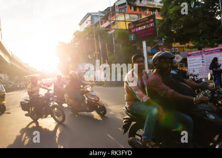 Soleil de l'après-midi Cours d'eau par les usagers sur leur moto sin Chennai, Inde du Sud, en tant que chef des travailleurs à la maison du travail Banque D'Images