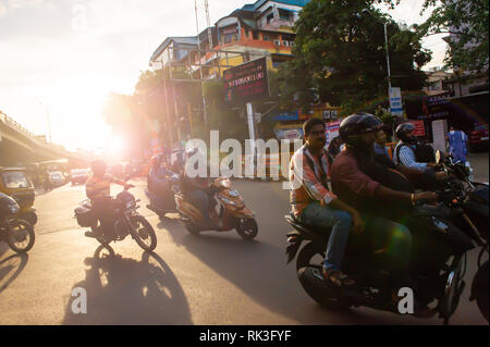 Soleil de l'après-midi Cours d'eau par les usagers sur leur moto sin Chennai, Inde du Sud, en tant que chef des travailleurs à la maison du travail Banque D'Images