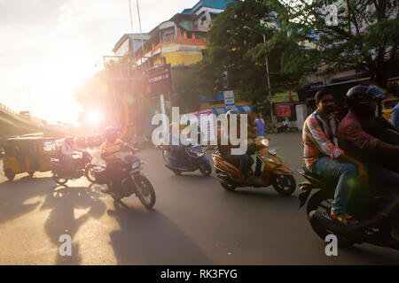 Soleil de l'après-midi Cours d'eau par les usagers sur leur moto sin Chennai, Inde du Sud, en tant que chef des travailleurs à la maison du travail Banque D'Images