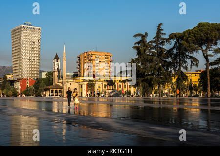 Jeune famille et d'autres sections locales à la place Skanderbeg, en face de la statue de Skanderbeg, Et'hem Bey mosque et un hôtel, Tirana, Albanie Banque D'Images