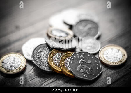 New Great British Pound GBP Coins portant sur haut de portefeuille noir sur la surface en bois. La richesse, l'argent, l'argent comptant, le changement. Banque D'Images