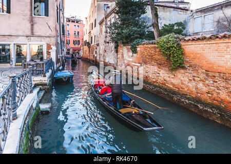 Venise, Italie - 10 février 2018 : Gondola passant dans un petit canal Banque D'Images