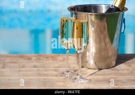 Verres de champagne et une bouteille dans un seau à glace près de la piscine. Vacances et romance concept Banque D'Images