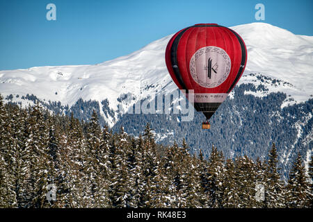 Une montgolfière flotte au-dessus des arbres dans la station alpine de Courchevel. Banque D'Images