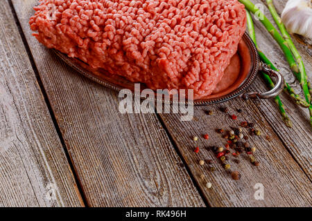 Avec la masse de viande hachée fraîche ingrédients pour la cuisson sur la vieille table de cuisine. Banque D'Images