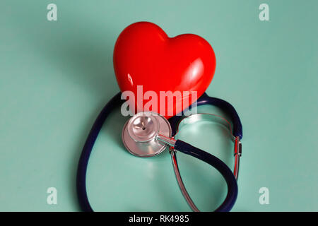 Coeur rouge avec stéthoscope sur fond en bois bleu. Banque D'Images