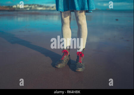 Les jambes et les pieds d'une jeune femme debout sur la plage en hiver Banque D'Images