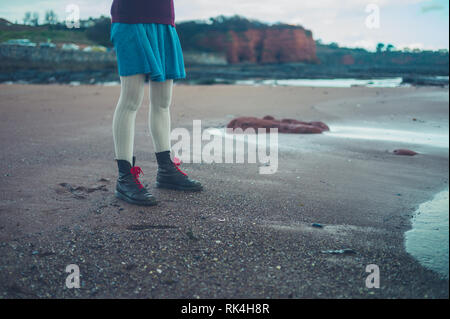 Les jambes et les pieds d'une jeune femme debout sur la plage en hiver Banque D'Images