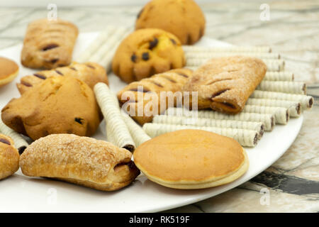 Processus de préparation du gingembre cookies en une maison de vacances. La pâte est disposé sur un fond bleu, des biscuits en forme de coeur et l'étoile. En un coup d'une main Banque D'Images