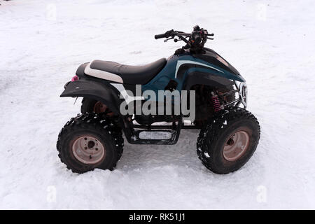 Close-up 4x4 ATV quad en forêt à l'hiver. Tous les 4RM-terreain stand véhicule dans la neige lourde avec l'écartement de voie profonde. Une aventure de saison sport extrême Banque D'Images
