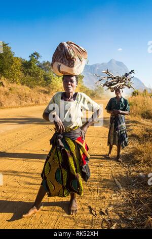 Les femmes locales transportant leurs marchandises sur leur tête avant mont Mulanje, Malawi, Afrique Banque D'Images