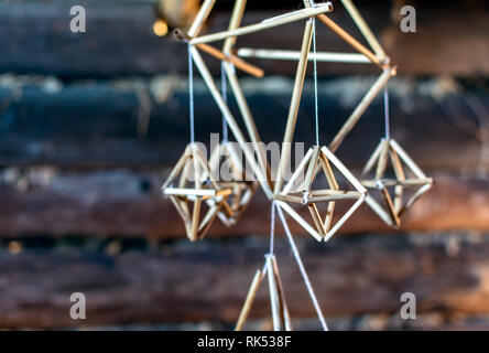 Puzurs letton accroché dans le noir log hut. Puzurs est traditionnelle décoration Chambre lettone de roseaux ou de paille. C'est symbole solstice similaire à Fi Banque D'Images