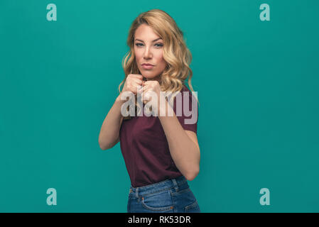 Belle jeune femme dans un boxer se posant sur un fond bleu. Banque D'Images