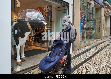 La figure de vache avec parapluie en entrée de magasin dans la ville de Porto, Portugal, Europe Banque D'Images