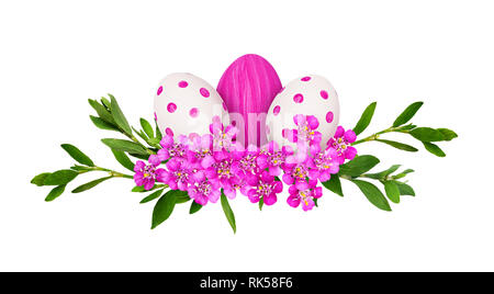 Les oeufs de Pâques, peint fleurs achillée rose et vert avec de petites feuilles d'herbe dans un arrangement de vacances isolated on white Banque D'Images