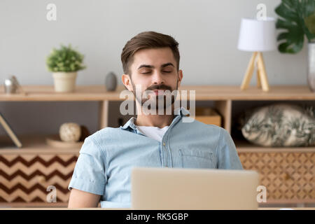 Heureux jeune homme détendu, les yeux fermés au repos de l'air respirable Banque D'Images