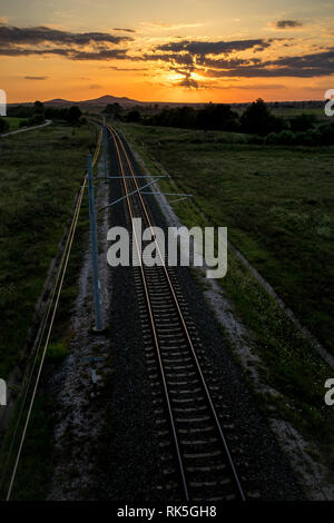 Les voies de chemin de fer vide longue vue d'un pont au-dessus de l'été au coucher du soleil derrière les nuages colorés, photo prise près de Krum, Bulgarie Banque D'Images