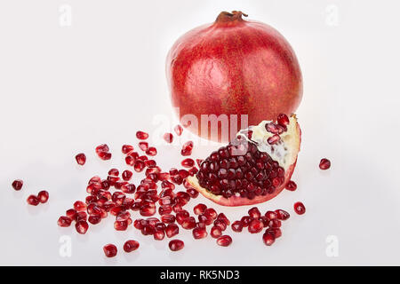 Close-up de graines de grenade texture sur un fond blanc, vue du dessus. Fruits mûrs rouge grenat Banque D'Images