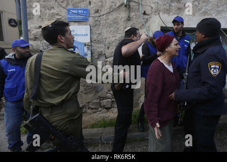 Hébron, en Cisjordanie, en territoire palestinien. 10 fév, 2019. Un colon juif soutient avec un policier israélien lors d'une manifestation par des militants palestiniens contre la fermeture de la rue Shuhada, sur le 25e anniversaire de la fermeture. Le 25 février, 1994 colon israélien Baruch Goldstein a ouvert le feu dans la mosquée, tuant 29 Palestiniens dans le culte. Depuis, la rue Shuhada, une fois la rue principale et du marché, est resté presque entièrement fermé aux Palestiniens. Il y a 20 points de contrôle et des portes avant de boutiques palestiniennes et h Crédit : ZUMA Press, Inc./Alamy Live News Banque D'Images