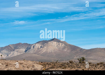 Ravine et rocky le désert d'un côté et le désert de sable de l'autre côté jusqu'à haute montagnes stériles sous ciel bleu avec des nuages blancs. Banque D'Images