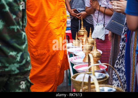 Les laïcs s'fond en donnant des offrandes de nourriture aux moines bouddhistes passe tous les jours dans toute l'aumône matin à mon pont, Sangkhlaburi, Kanchanaburi, Thail Banque D'Images