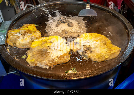 Les aliments de rue taïwanais - omelette d'huîtres sur la plaque chaude, à un fournisseur d'aliments de rue dans le marché de nuit à Taipei, Taiwan Banque D'Images