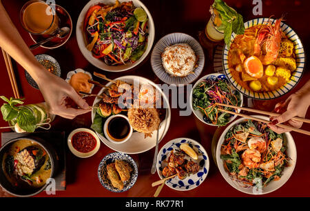 Sélection de plats thaïlandais, vue de dessus avec plusieurs plats tels que soupes, brochettes, salades, boissons et desserts. Banque D'Images