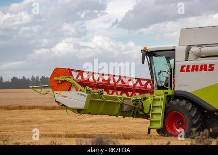 Close-up d'une moissonneuse-batteuse Claas travaillant dans un champ d'orge en été en Nouvelle-Zélande Banque D'Images