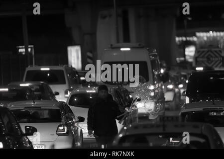 L'homme du vendeur vend des ballons lumineux à led de nuit à l'autoroute pendant un embouteillage à Altunizade, côté asiatique d'Istanbul en noir et blanc. Banque D'Images