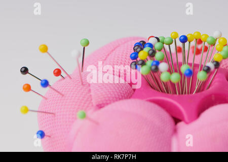 Aiguille rose coussin avec un grand nombre de broches de couleur, couleur horizontal macro photo with copy space Banque D'Images