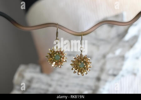 Vintage boucles d'en laiton sous la forme d'une fleur sur la pierre blanche, fait main Banque D'Images