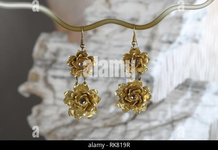 Vintage boucles d'en laiton sous la forme d'une fleur sur la pierre blanche, fait main Banque D'Images