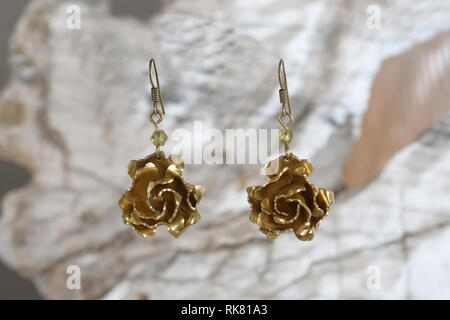 Vintage boucles d'en laiton sous la forme d'une fleur sur la pierre blanche, fait main Banque D'Images