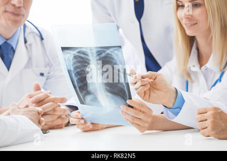 Groupe de médecins regarder et discuter la radiographie du thorax dans une clinique ou un hôpital Banque D'Images