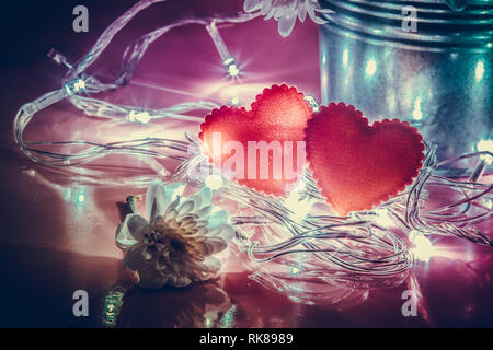 Coeur scintillant rouge et l'ampoule d'éclairage en aluminium avec godet sur fond rose. Allumer la lumière de l'amour à la Saint-Valentin concept. Banque D'Images