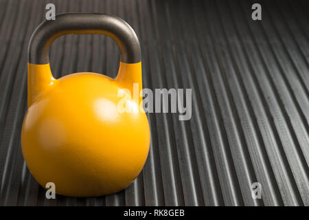 Le levage de poids 16kg jaune à l'intérieur d'une salle de sport. kettlebell Copie espace à droite de kettlebell. Banque D'Images