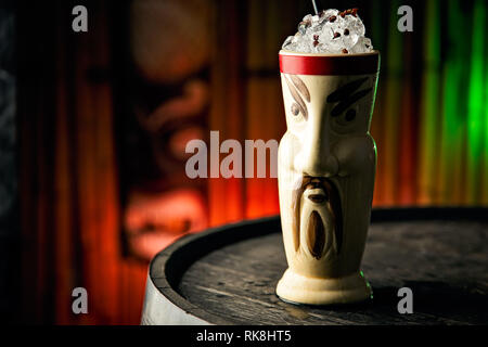 Savoureuse boisson Tiki servie dans la tasse Tiki à l'aspect asiatique avec glace pilée et épices Banque D'Images