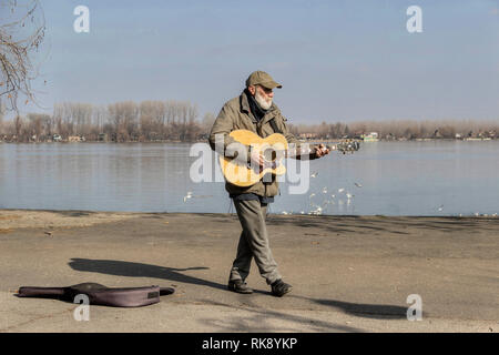 Belgrade, Serbie, février 2019 - musicien de rue à jouer avec sa guitare sur la promenade le long du Danube waterfront à Zemun Banque D'Images