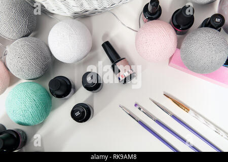 Accessoires pour la décoration des ongles sur un tableau blanc. Vernis à ongles et manucure balais sur la table. Banque D'Images