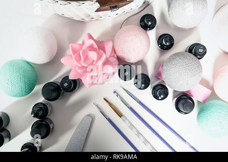 Accessoires pour la décoration des ongles sur un tableau blanc. Vernis à ongles et manucure balais sur la table. Banque D'Images