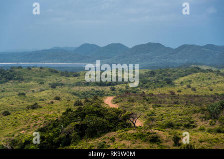 Une route de terre s'enroulant vers les dunes lointaines de l'estuaire St Lucia en zone humide d'Isimangaliso, Afrique du Sud Banque D'Images