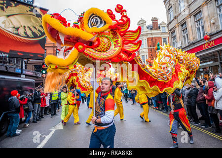 Les danseurs et les enfants en Lion parade de costumes autour des bords de Chinatown et Soho. Les célébrations du Nouvel An chinois à Soho, Londres. Banque D'Images