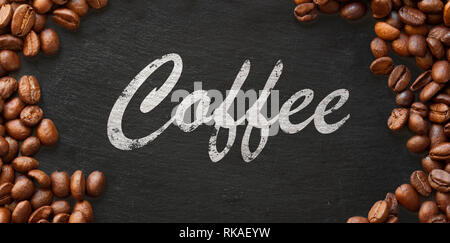 Le café à la main sur fond sombre encadrée avec les grains de café Banque D'Images