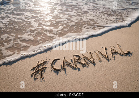 Message moderne pour le carnaval avec un social media-friendly hashtag écrit sur plage de sable lisse Banque D'Images