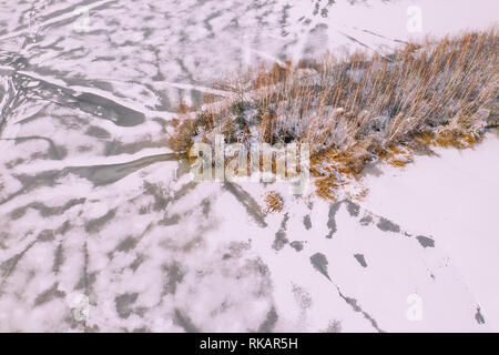 Vue aérienne de la forêt couverte de neige en hiver et au-dessus du lac gelé saisie à un drone. Banque D'Images